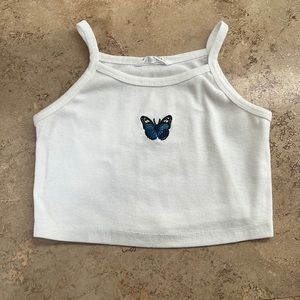 A white top with a blue butterfly